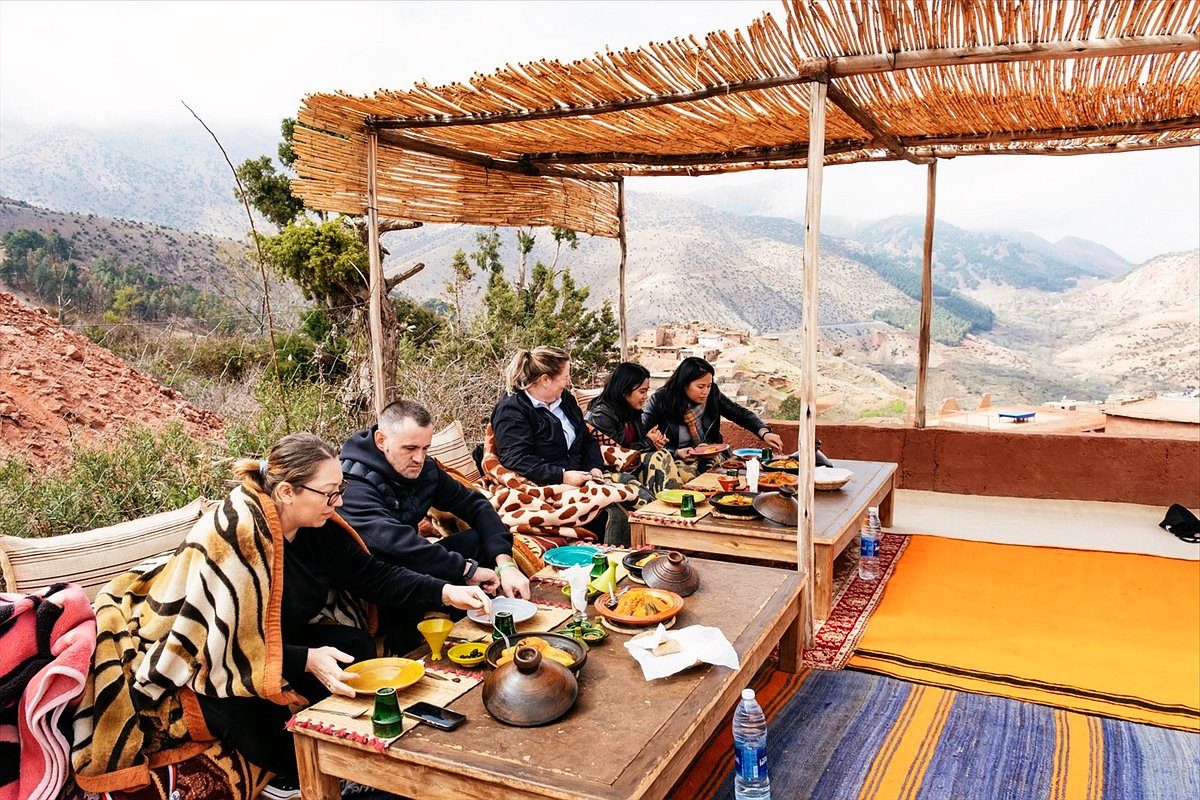Viaggiatori a pranzo su una terrazza affacciata sull’Alto Atlante